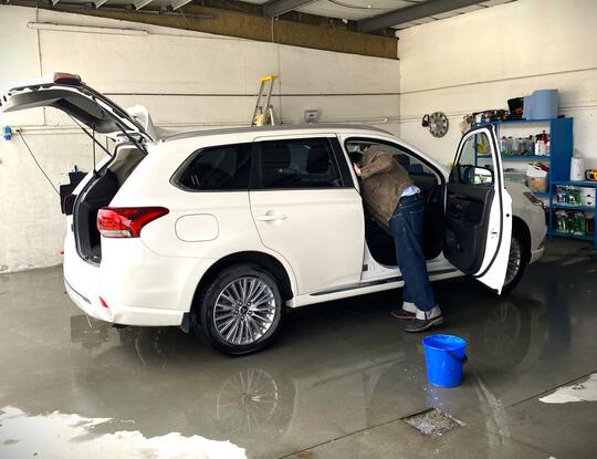Mann vasker hvit bil